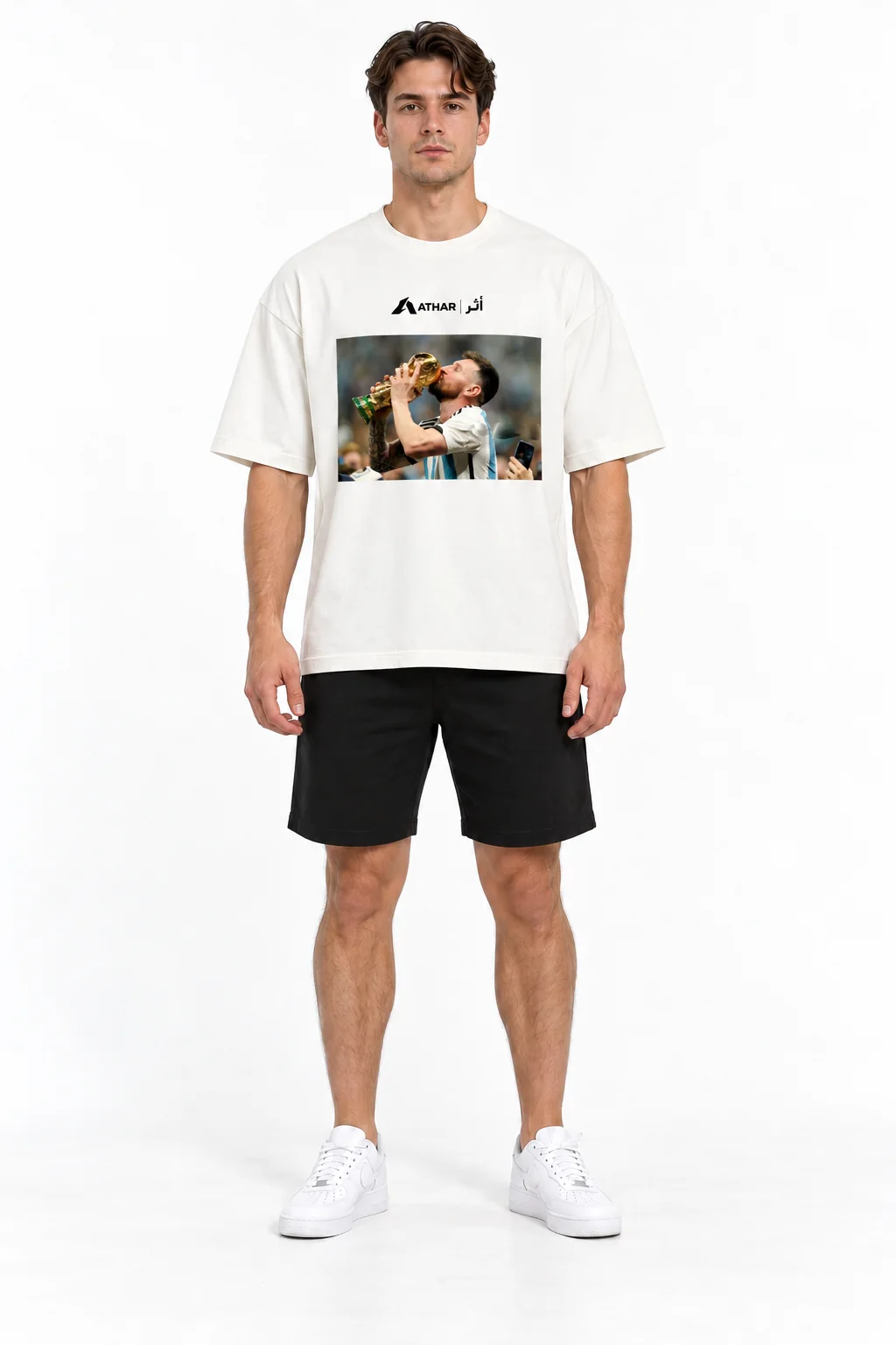 Modelo de frente usando a camiseta La Pulga branca, com Messi e a taça da Copa do Mundo