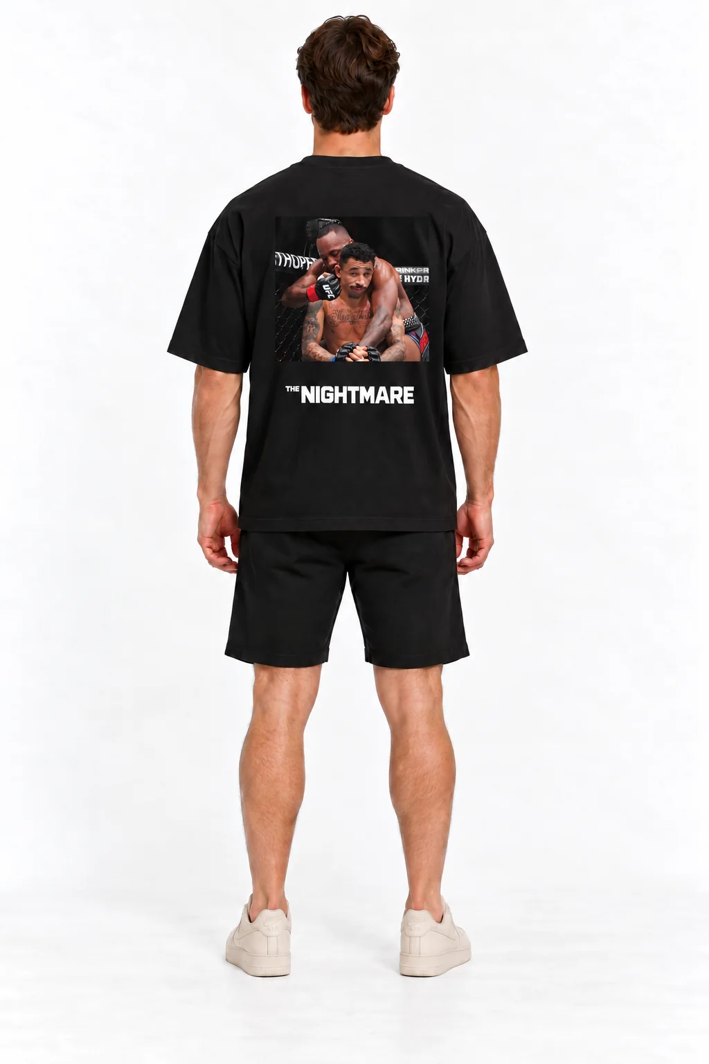Modelo de costas usando a camiseta Unbothered preta, com Carlos Prates e a estampa The Nightmare