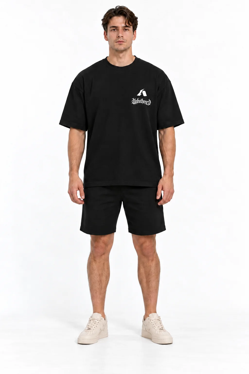 Modelo de frente usando a camiseta Unbothered preta, com logo Athar e lettering na lateral do peito